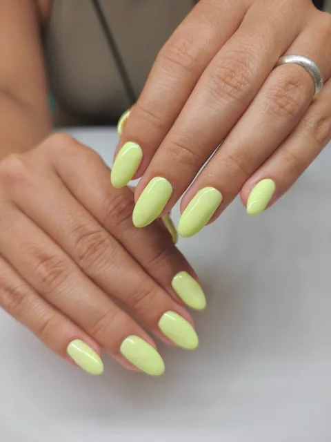 Manicura almendrada en amarillo lima brillante.