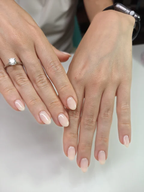 Manicura corta en tono nude rosado de acabado brillante.